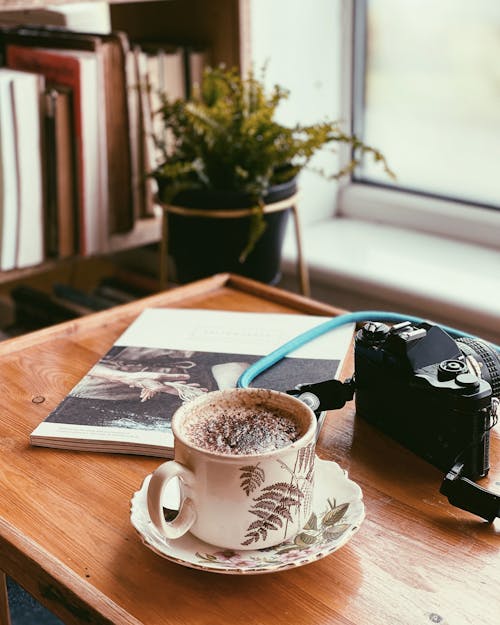 Coffee Cup, Book and Camera Near Window