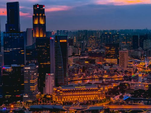 Free A breathtaking view of Singapore's illuminated cityscape at twilight showcasing modern skyscrapers. Stock Photo
