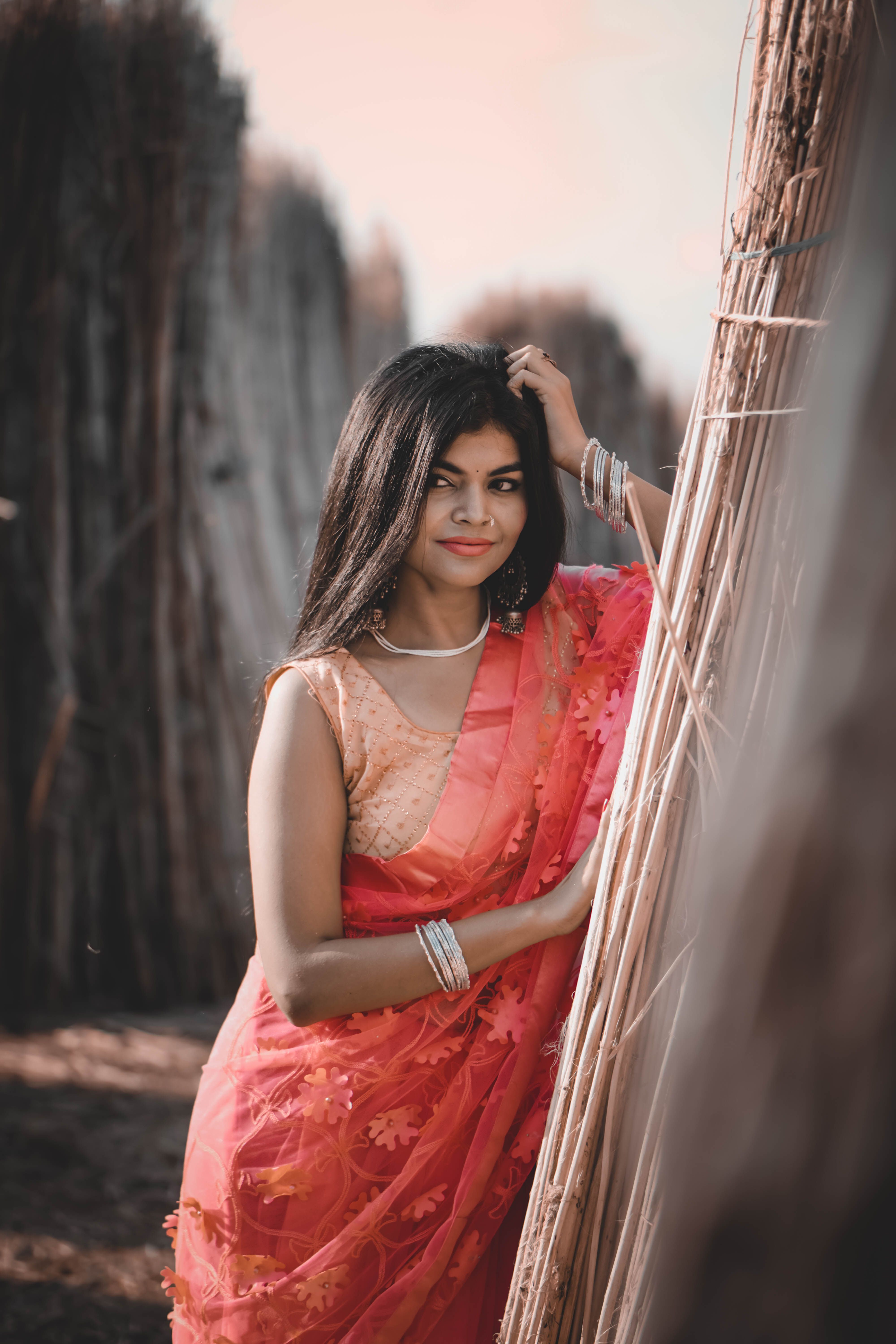 A beautiful woman in a vibrant saree posing gracefully outdoors in Kolkata, India.