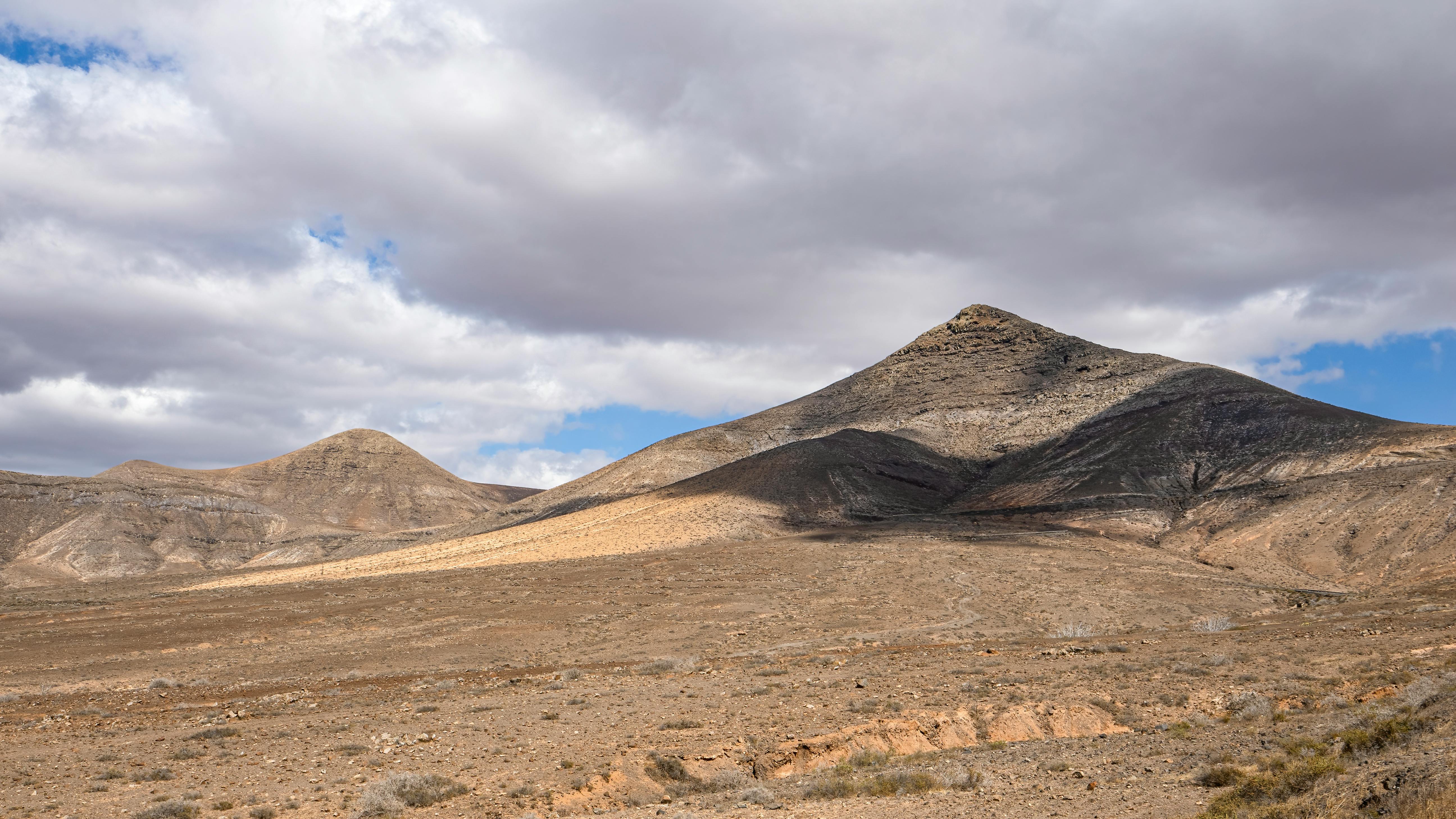 Beautiful desert landscape with hills under a cloudy sky, perfect for travel and nature imagery.