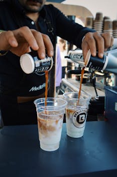 Barista crafting delicious iced coffees in a bustling café environment.