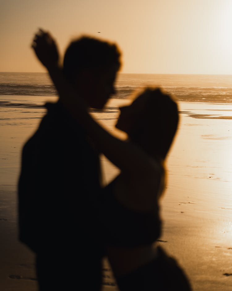 Embracing Couple On Beach At Sunset