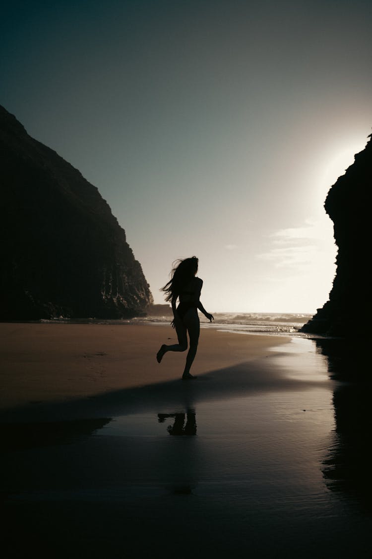 Woman Running On Beach At Dawn