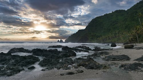 Rocks on Beach on Sea Shore at Sunset