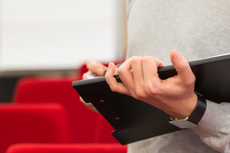 Close-up Of Man Holding Folder In Hands