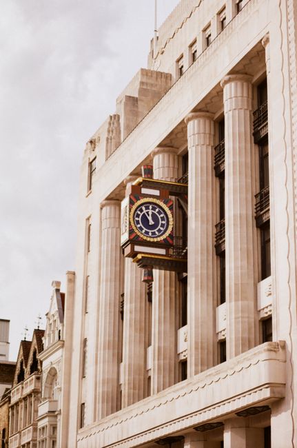 Capture of classic London architecture featuring columns and a prominent clock on a historic building facade.