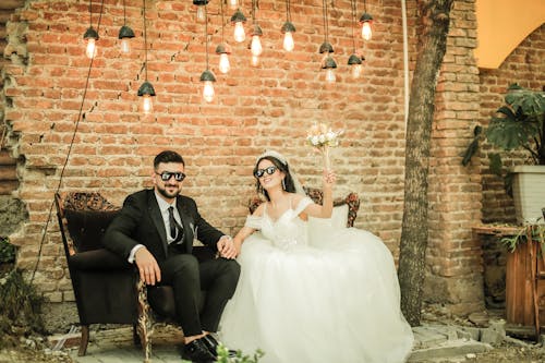 Smiling Newlyweds in Sunglasses Sitting on Armchairs