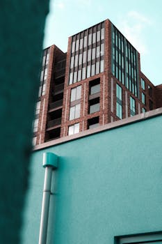 从低视角看当代城市公寓，可见砖砌外墙和玻璃窗