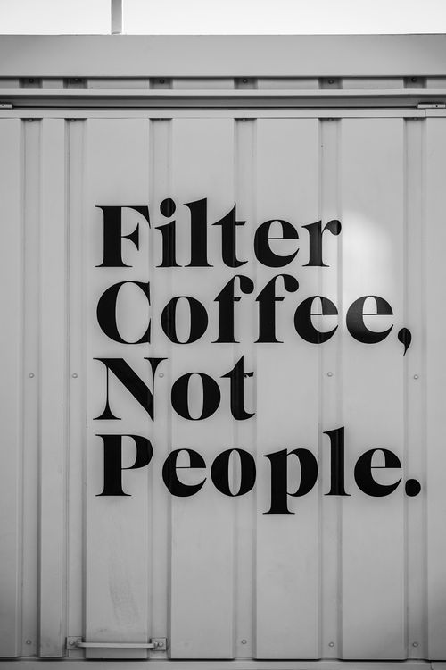Free Black typography on a white wall with an inspirational coffee message in Ankara. Stock Photo