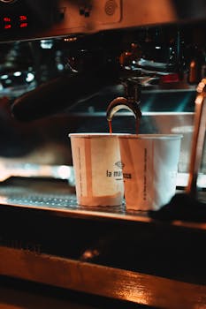 Espresso pouring into cups from a shiny coffee machine in Ankara café.