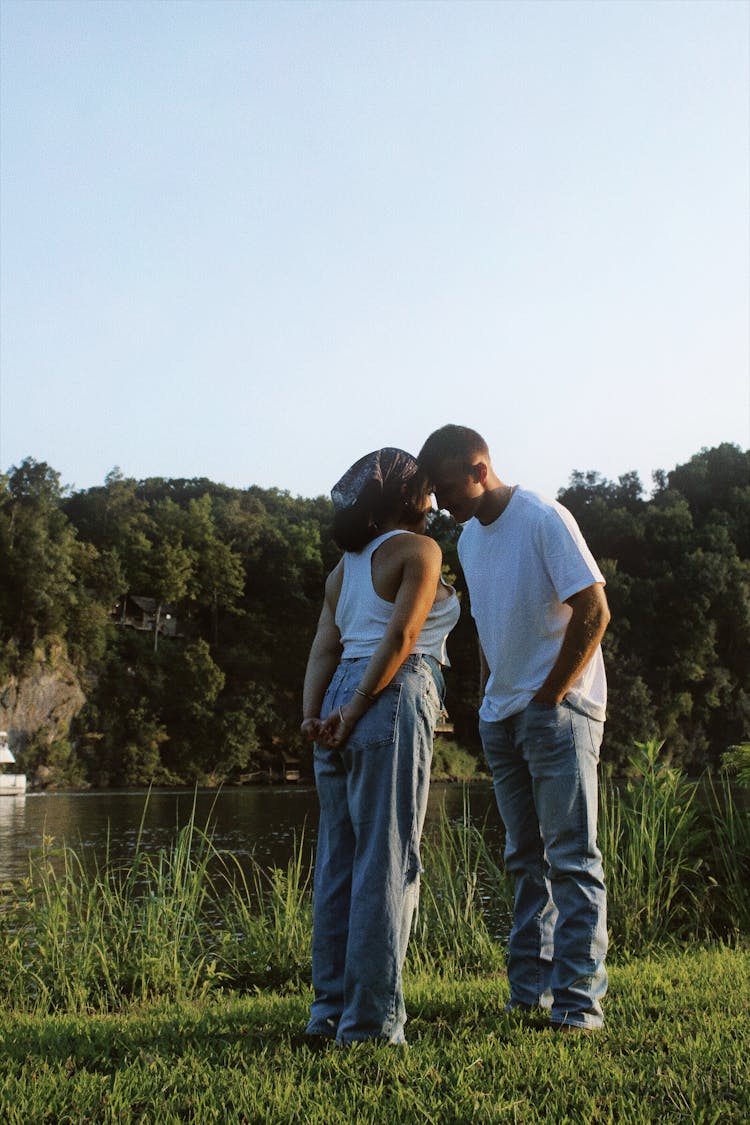 Couple Touching Foreheads Standing On River Bank