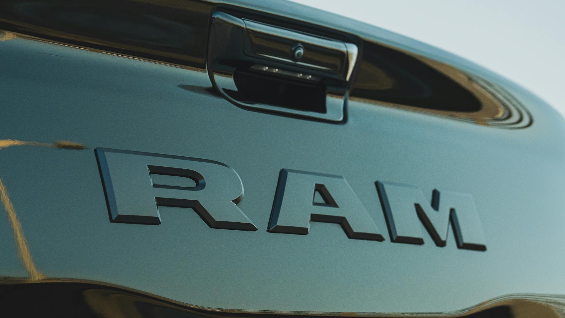 Detailed close-up of the RAM truck logo on a vehicle hood, showcasing automotive branding.