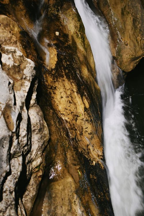 Free Captivating waterfall flowing through eroded rock canyon with vibrant textures. Stock Photo