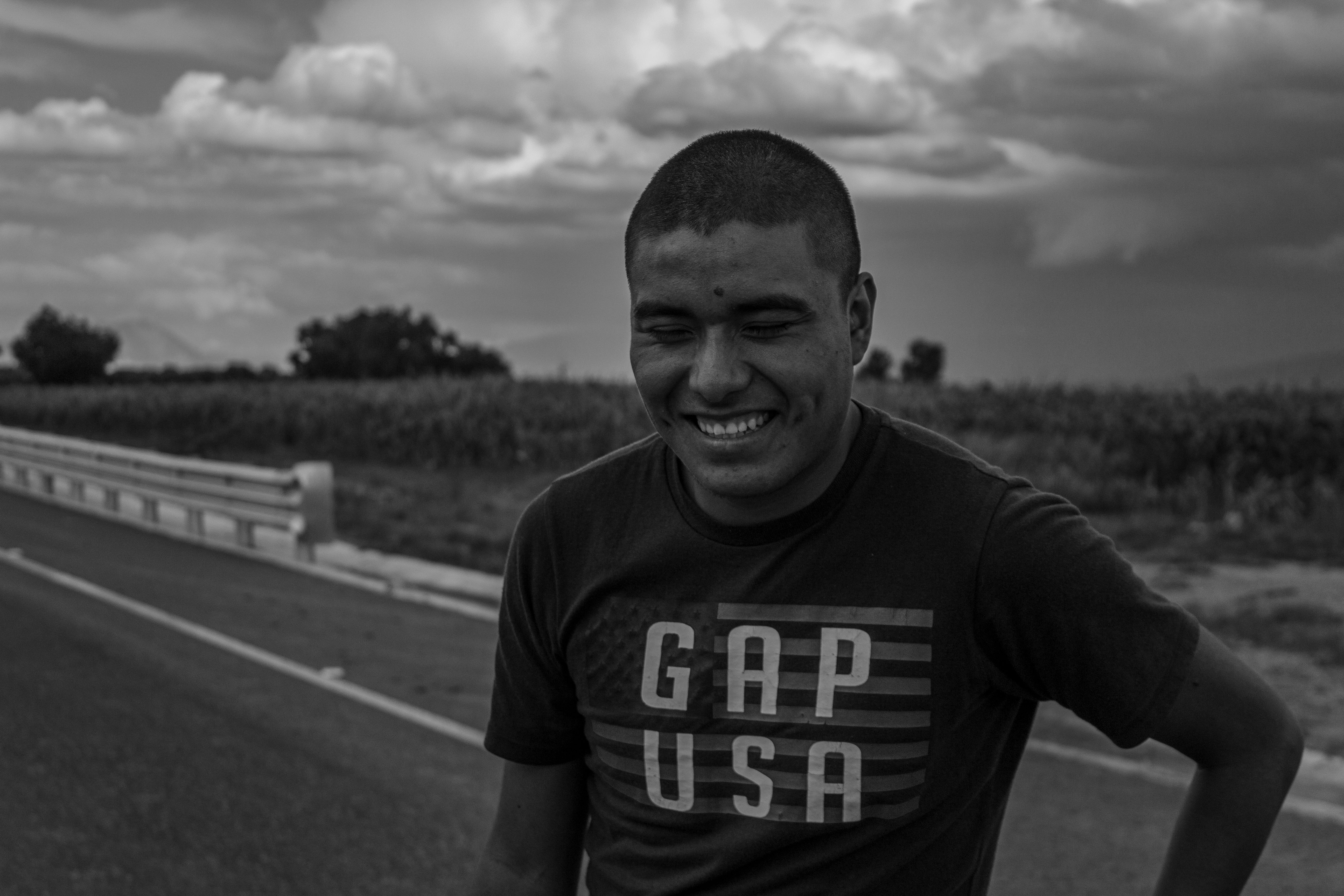 Black and white portrait of a smiling man on a rural road in Nopalucan de la Granja, México.