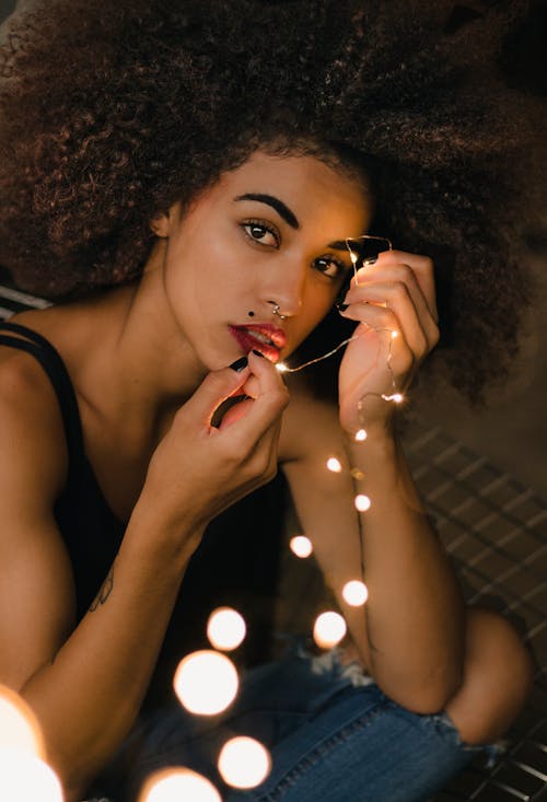 Woman Wearing Black Top Holding String Lights