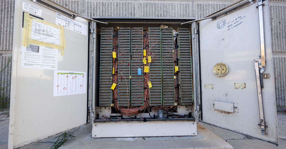 Open outdoor telephone junction box showing internal wiring and connectors.