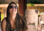 一位戴着太阳镜的女人在户外微笑着享受阳光明媚的一天