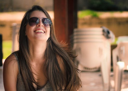 一位戴着太阳镜的女人在户外微笑着享受阳光明媚的一天