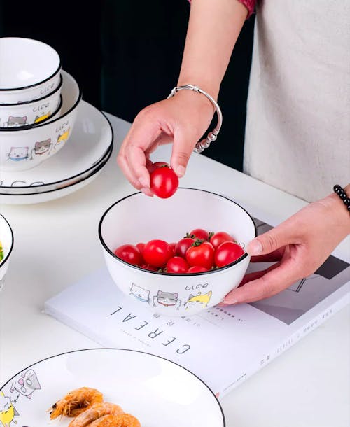 Woman with Fresh Ripe Tomatoes in Bowl in Kitchen