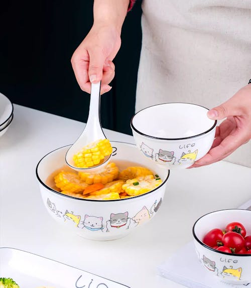 Cook Holding a Spoon with Corn Soup and Empty Bowl