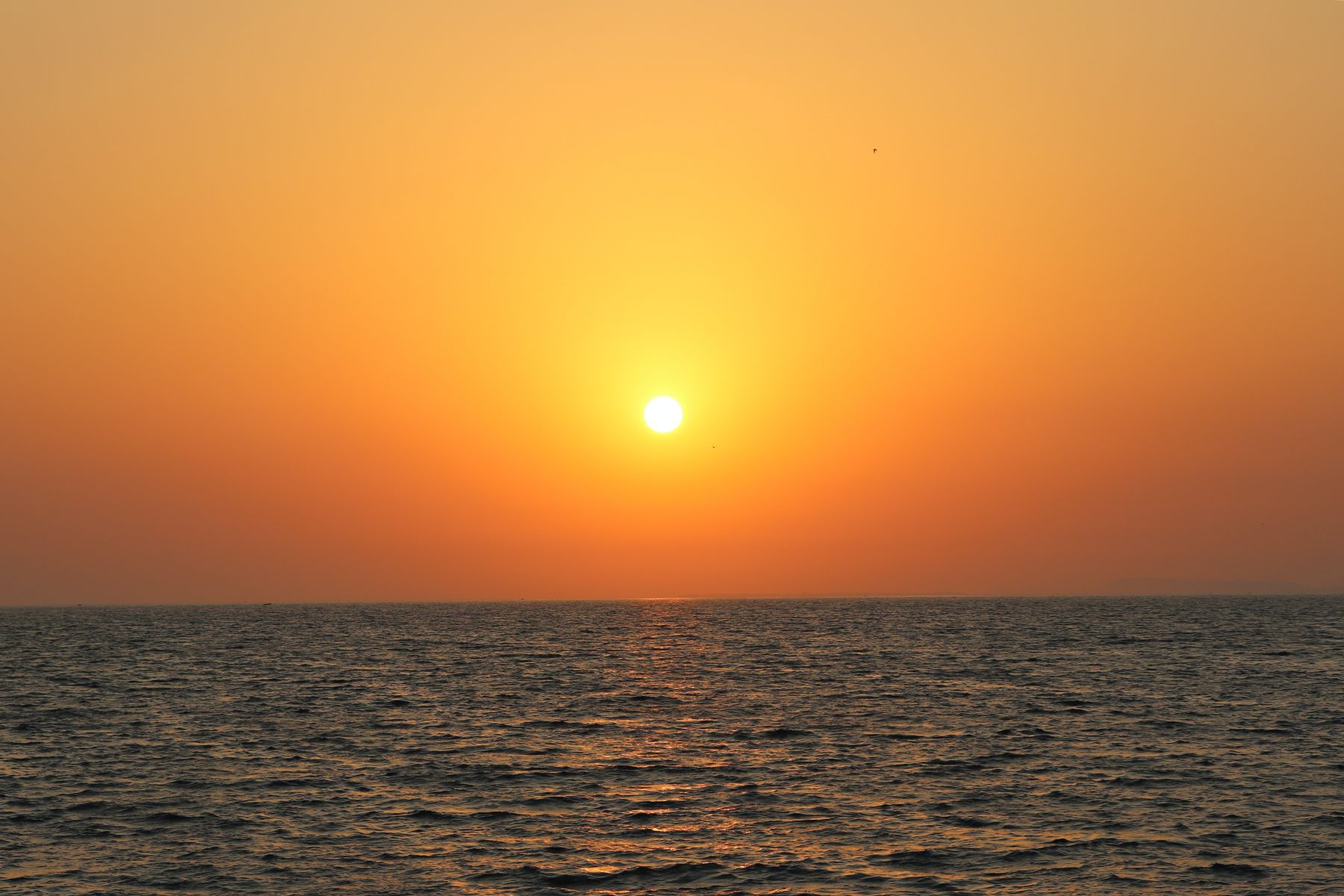 A breathtaking sunset over the ocean in Gwadar, Pakistan, casting warm hues across the water.