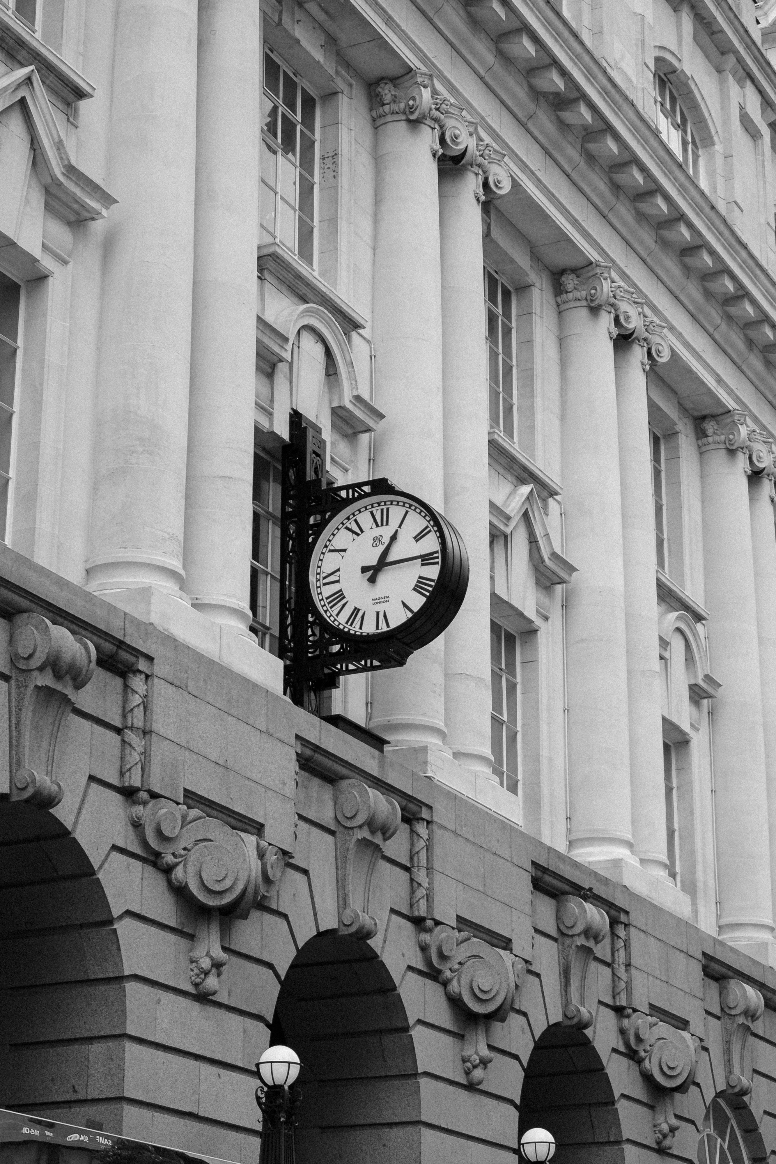 Clock on Ornamented Building Wall · Free Stock Photo
