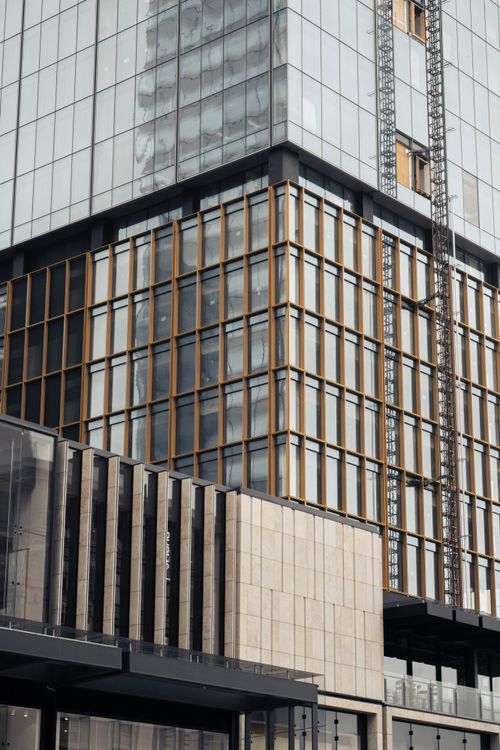 Free Detailed view of a modern office building with glass and metal facade in an urban setting. Stock Photo