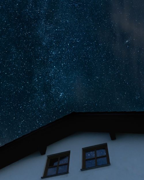 Free A clear night sky filled with stars over a house roof. Perfect for astronomy and tranquility themes. Stock Photo