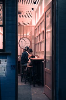 A couple enjoying a meal in a Japanese restaurant, viewed through a doorway with warm lighting.