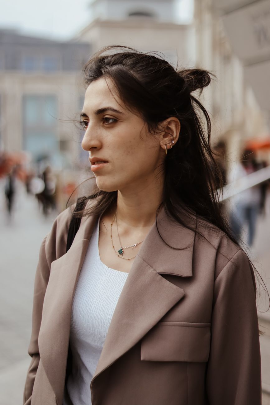 Confident woman with stylish outfit in city street, depicting modern urban lifestyle.