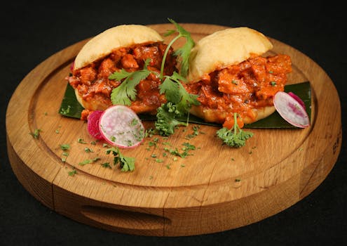 Vibrant Indian pav bhaji served on a cutting board with garnish.