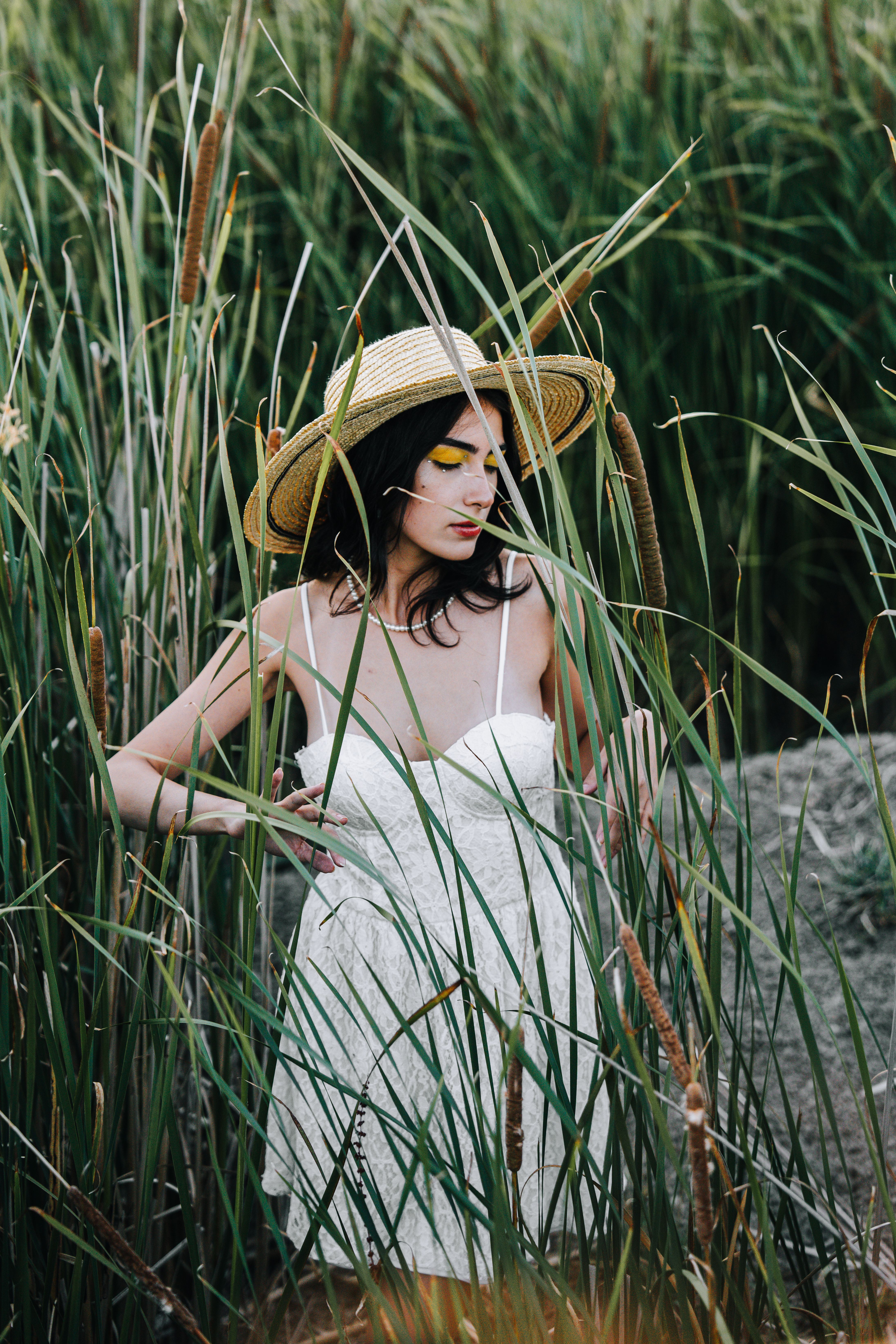Woman in a Sundress and a Hat Standing in Tall Grass · Free Stock Photo