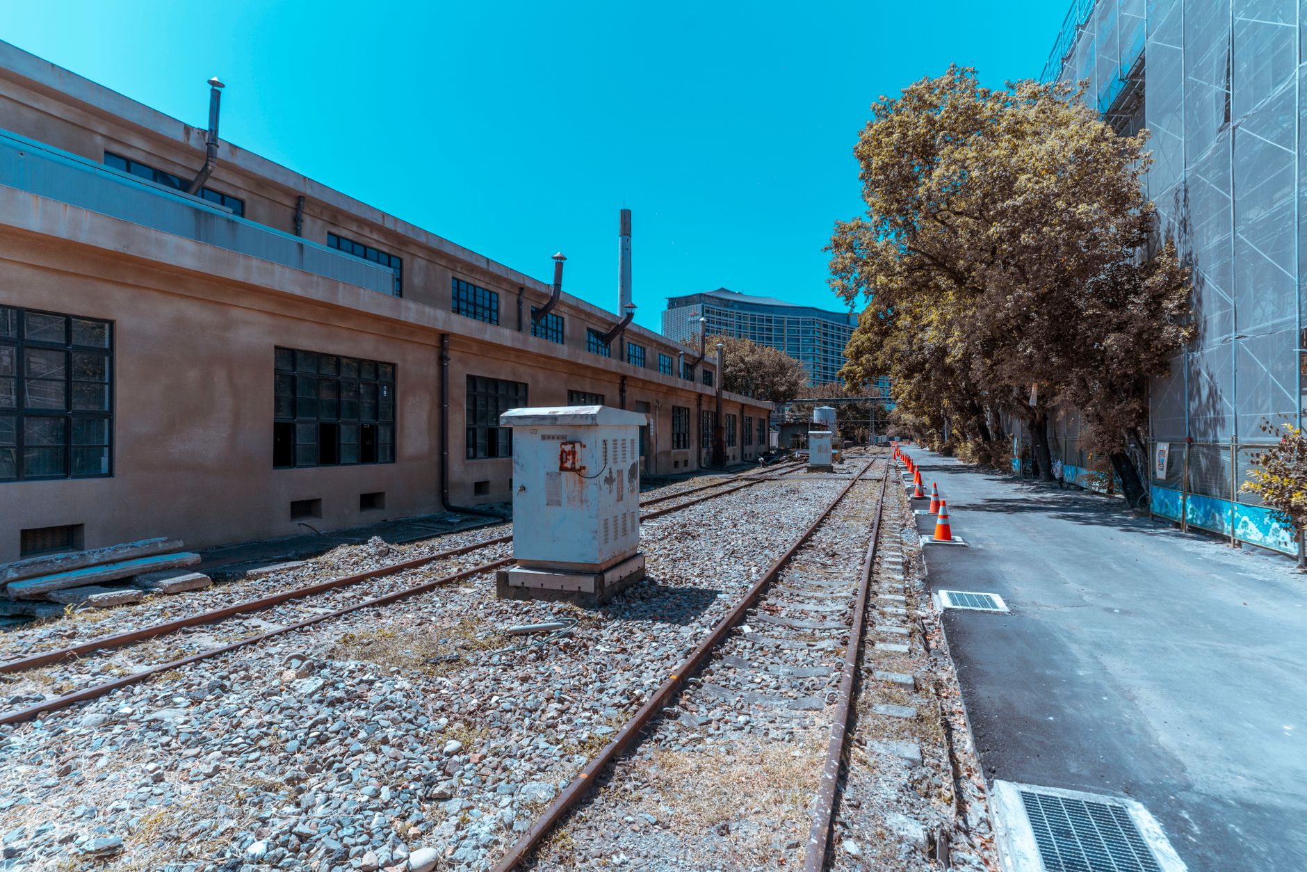 An industrial urban scene with deserted railroad tracks and buildings, exhibiting a vintage feel.
