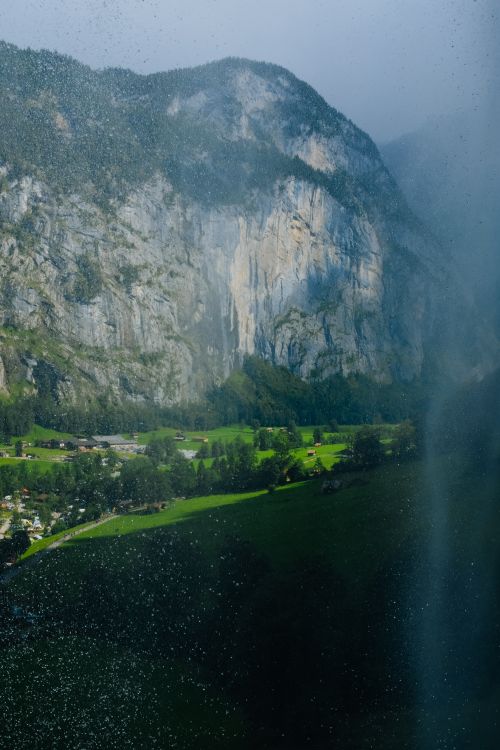 Free Majestic mountain landscape with a picturesque valley and misty waterfall. Perfect for nature and travel themes. Stock Photo