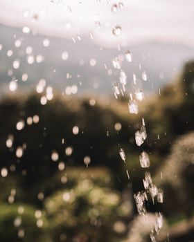 Captivating shot of water droplets falling with a scenic nature view in Stresa, Italy.