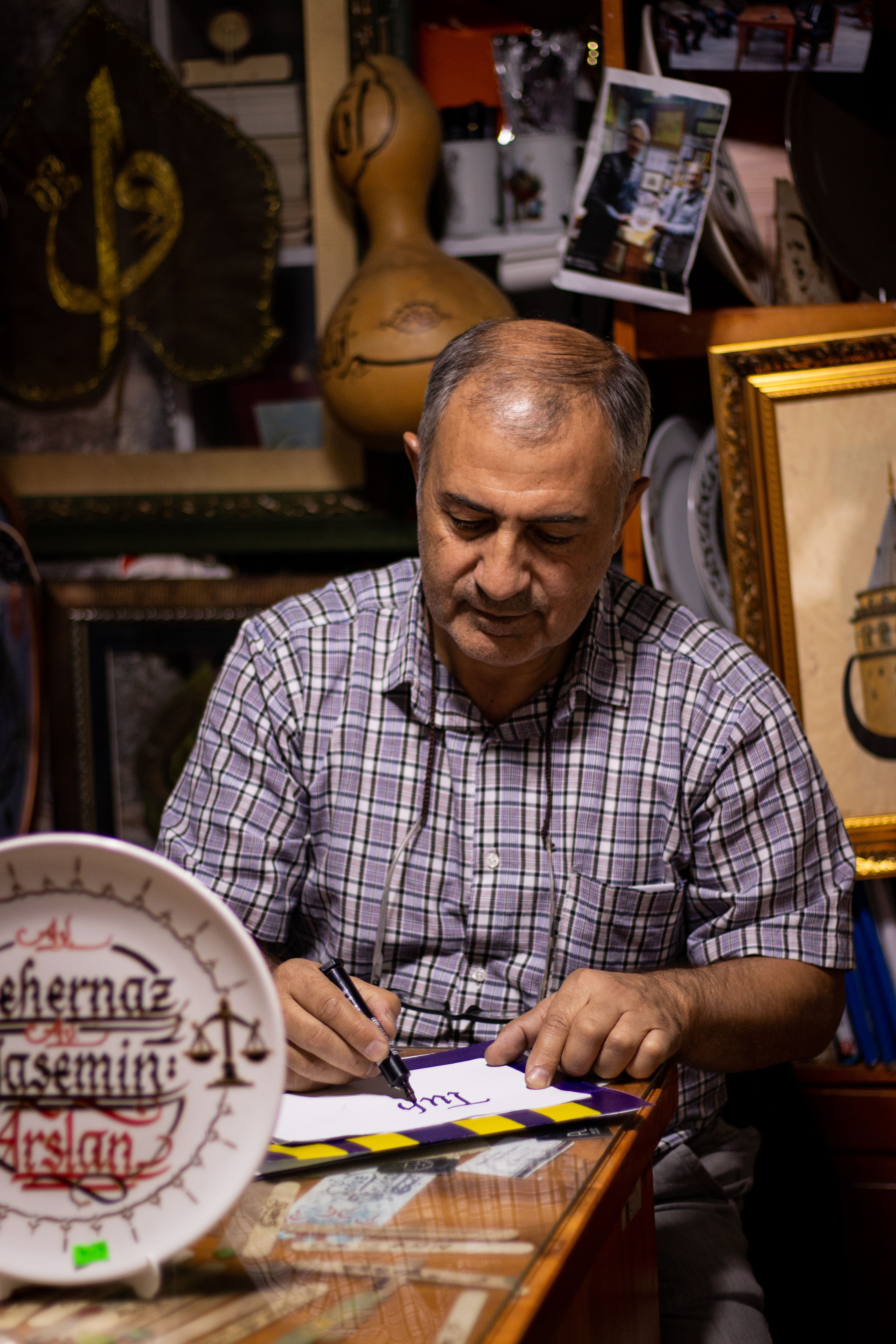 Middle-aged man writing in a cultural shop in Kayseri, Türkiye.