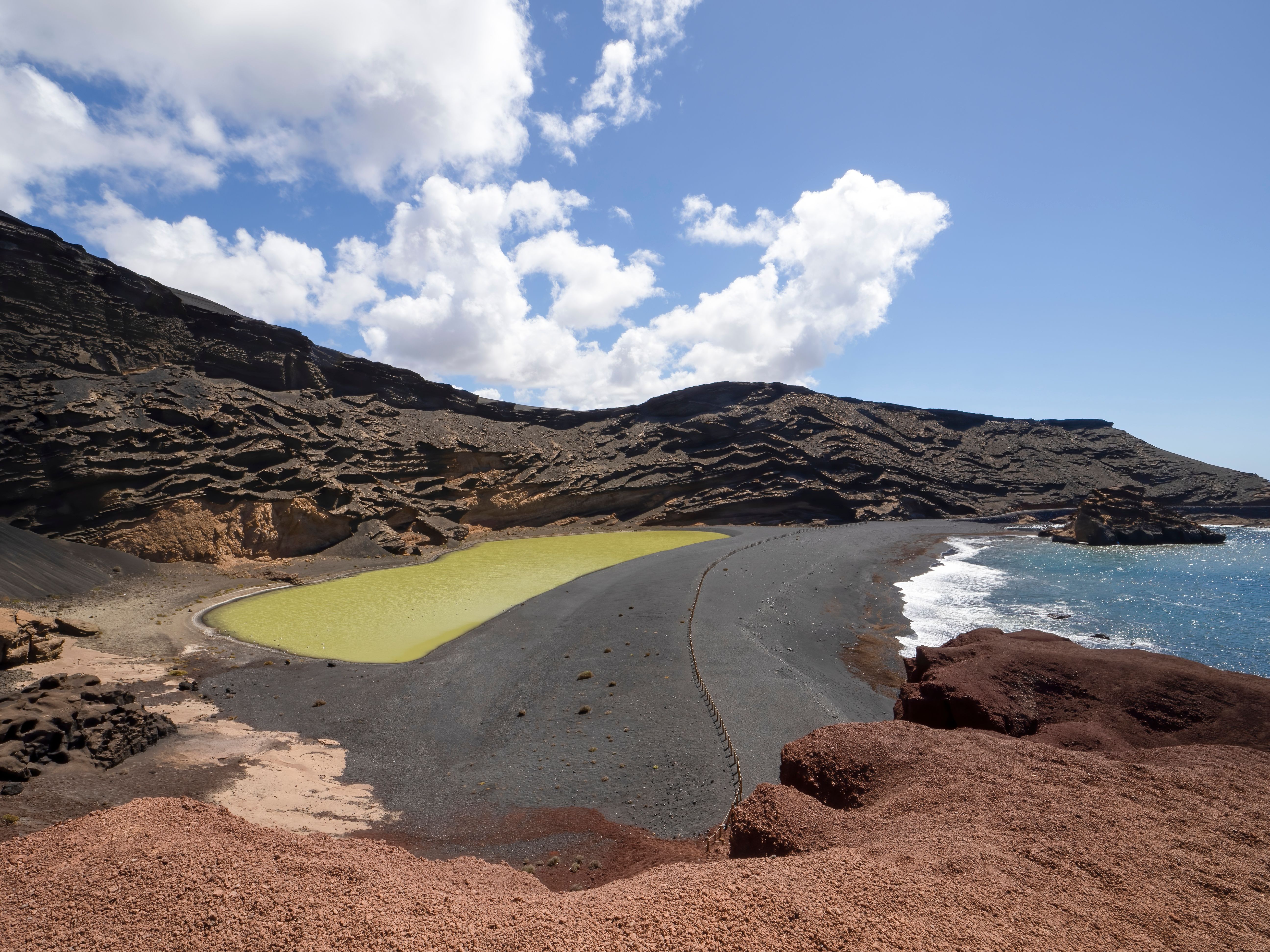 Scenic view of El Golfo's Charco Verde Lagoon and rocky coast in Lanzarote, Spain.
