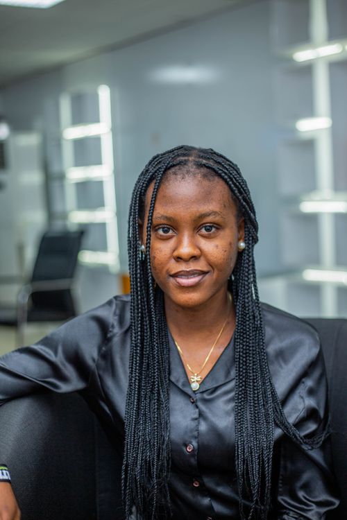 Free Portrait of a confident African woman sitting indoors in a modern setting. Stock Photo