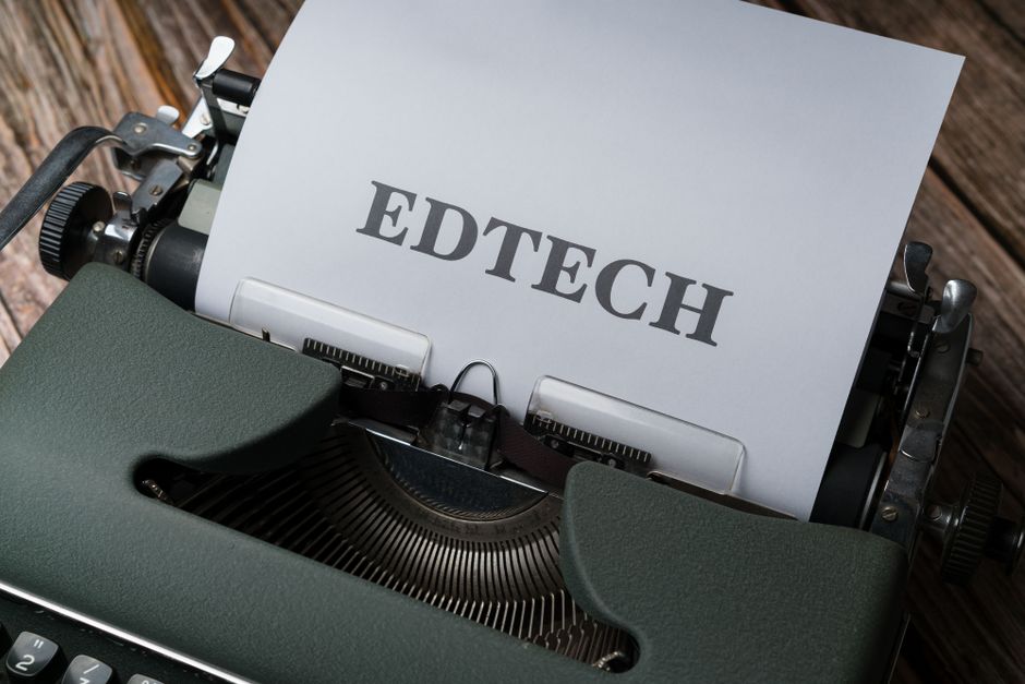 A classic typewriter with a sheet of paper displaying the word ‘EDTECH.’