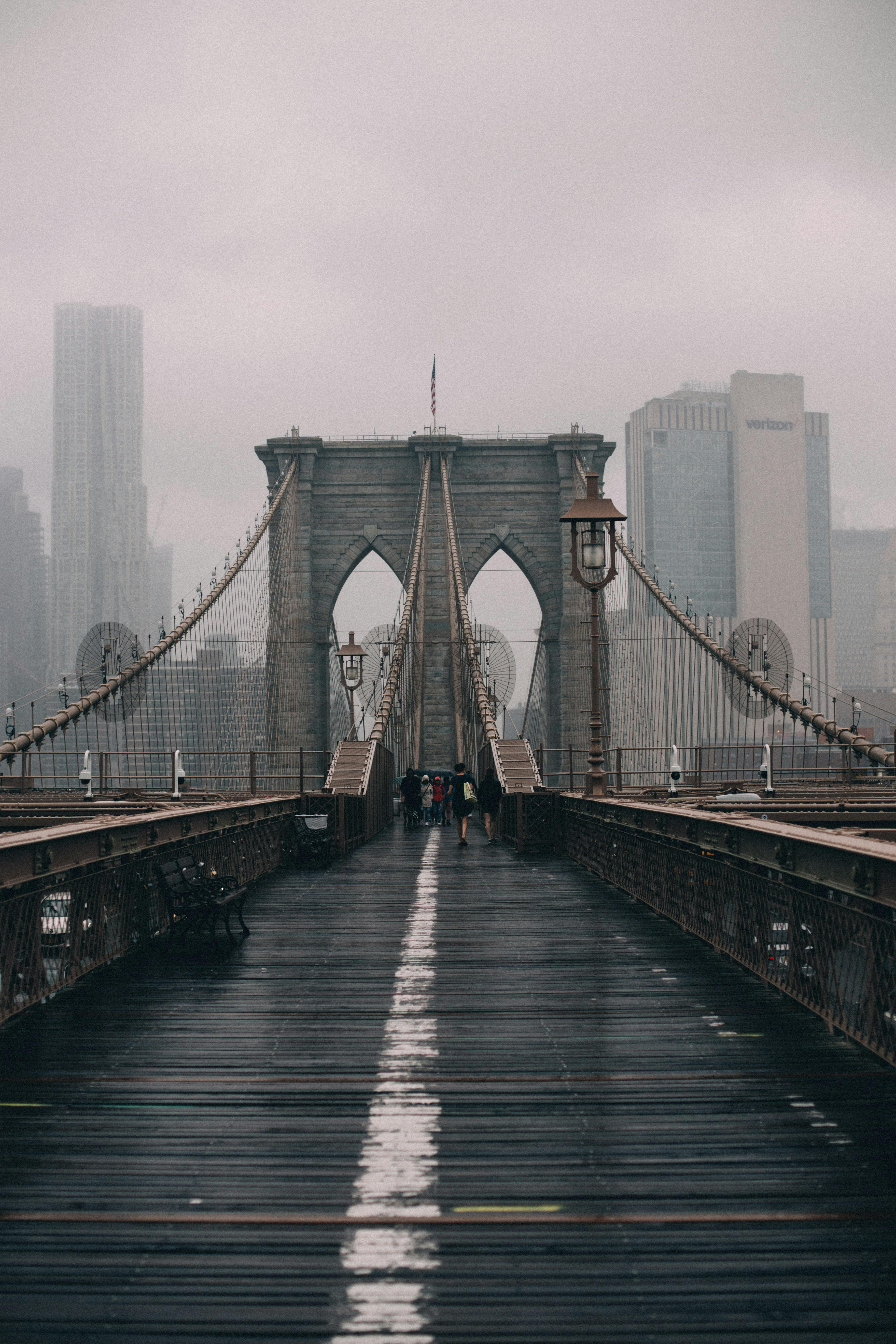 A foggy view of the iconic Brooklyn Bridge with the New York City skyline in the background.