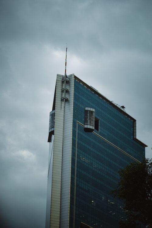 Free Tall modern skyscraper in Ciudad de México captured under a cloudy sky, showcasing contemporary architecture. Stock Photo