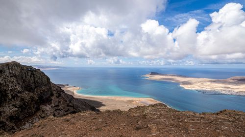 Free Stunning view of rocky cliffs overlooking a tranquil coastal bay under a bright blue sky. Stock Photo