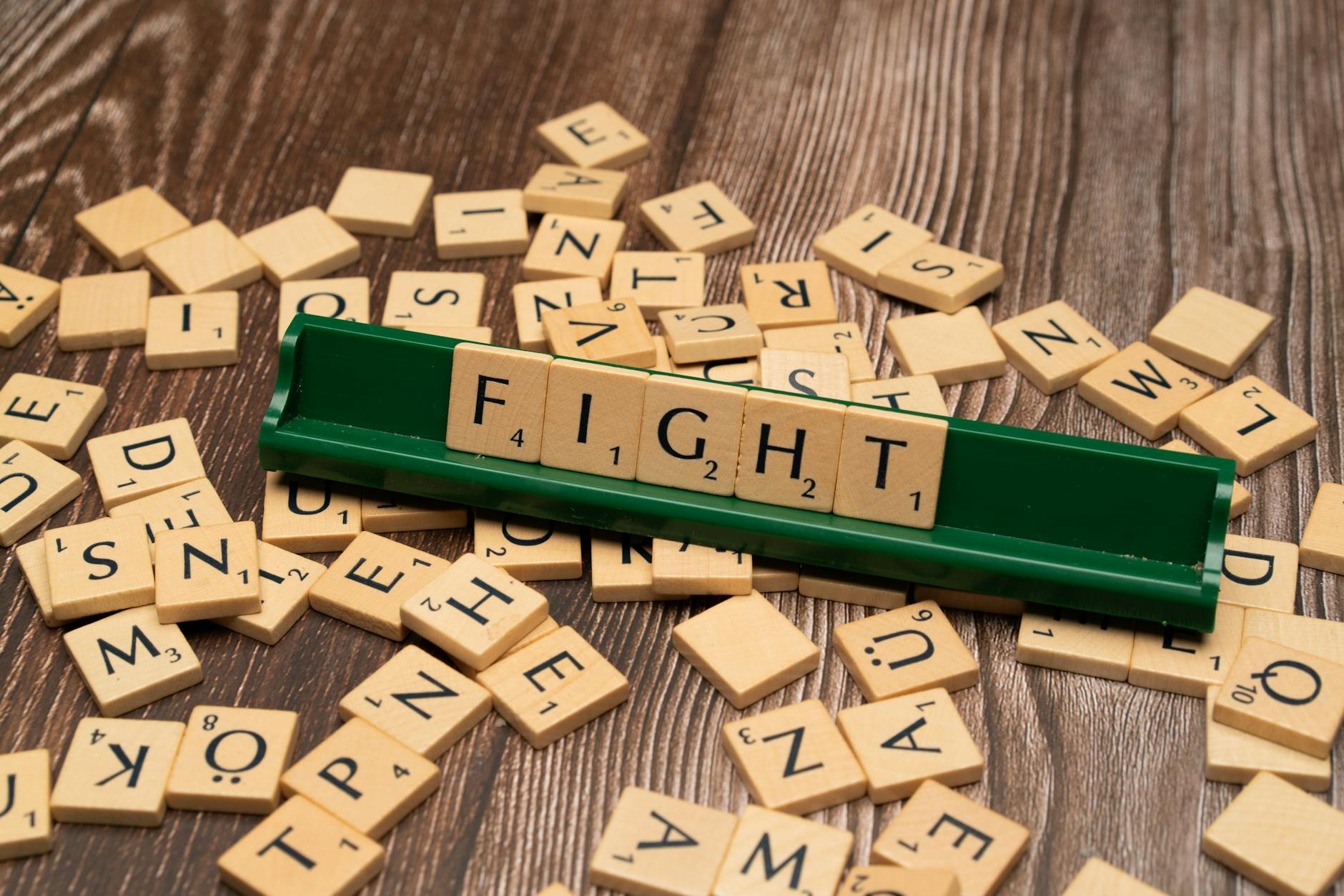 The word fight is spelled out in scrabble tiles