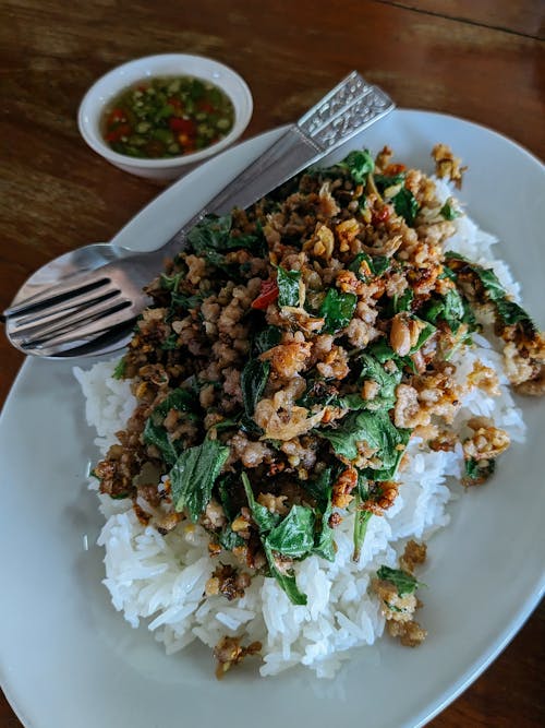 A plate of rice topped with meat and vegetables