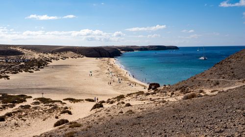 Free Scenic view of Papagayo Beach in Lanzarote with azure waters and sandy shores under a clear sky. Stock Photo