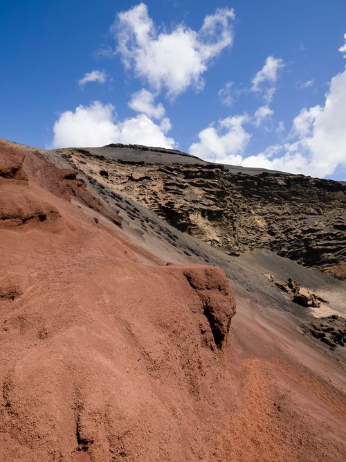 Free Capture the beauty of a rugged volcanic cliff under a clear blue sky, showcasing erosion and natural earth hues. Stock Photo
