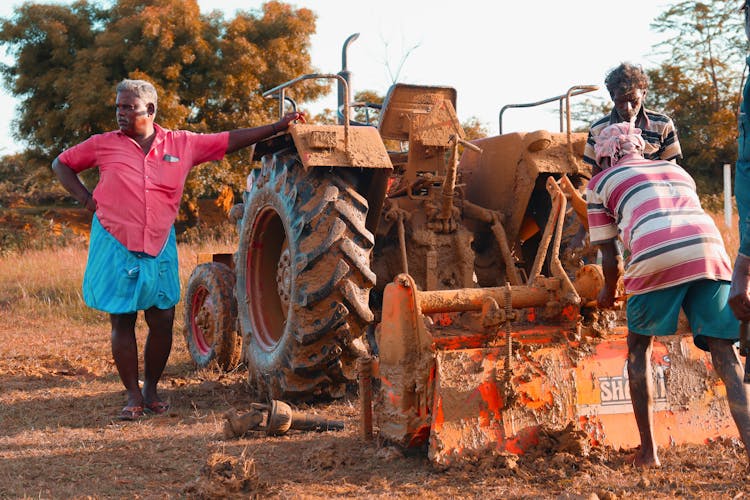 Farmers Standing By Vintage Tractor