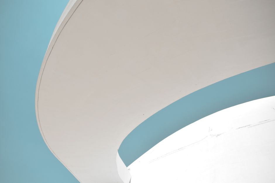 Abstract architectural detail featuring curves against a blue sky.