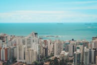 现代沿海城市在高视角下，摩天大楼与海洋背景交相辉映