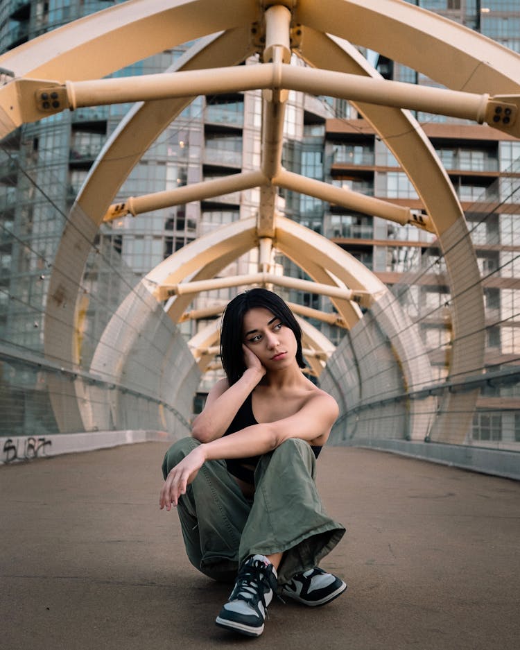 Woman Sitting On A Bridge